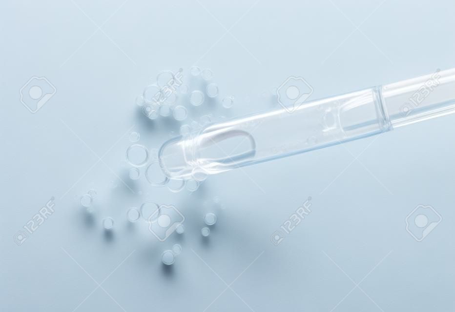 Serum in Pipette isoliert auf weißem Hintergrund. Kosmetischer flüssiger Tropfer mit Draufsicht der Blasen