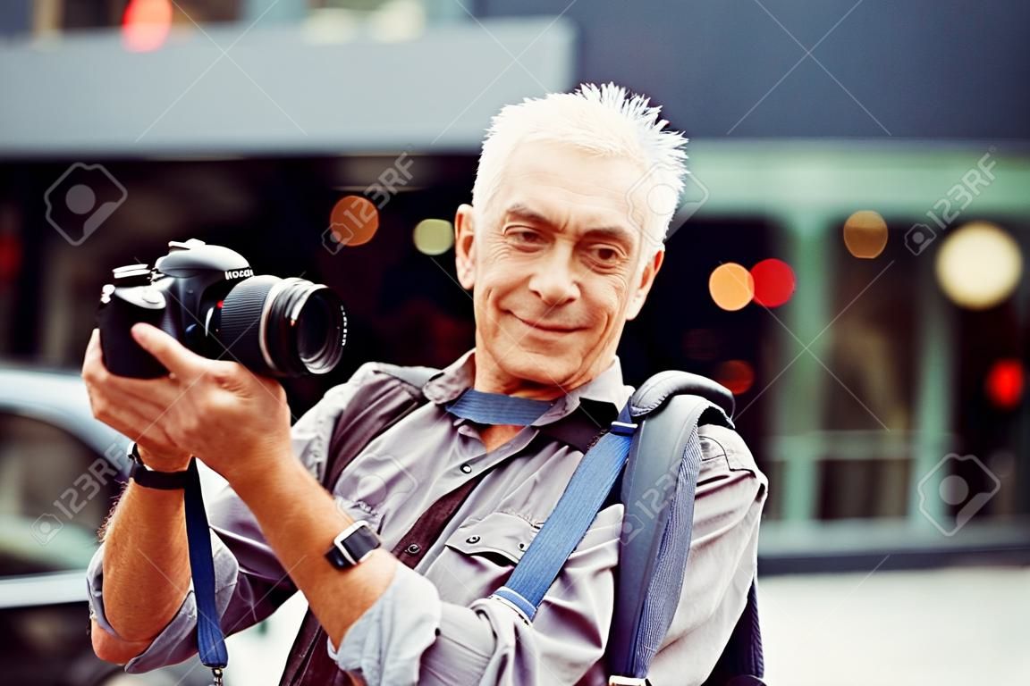 Hombre mayor con la cámara en la ciudad