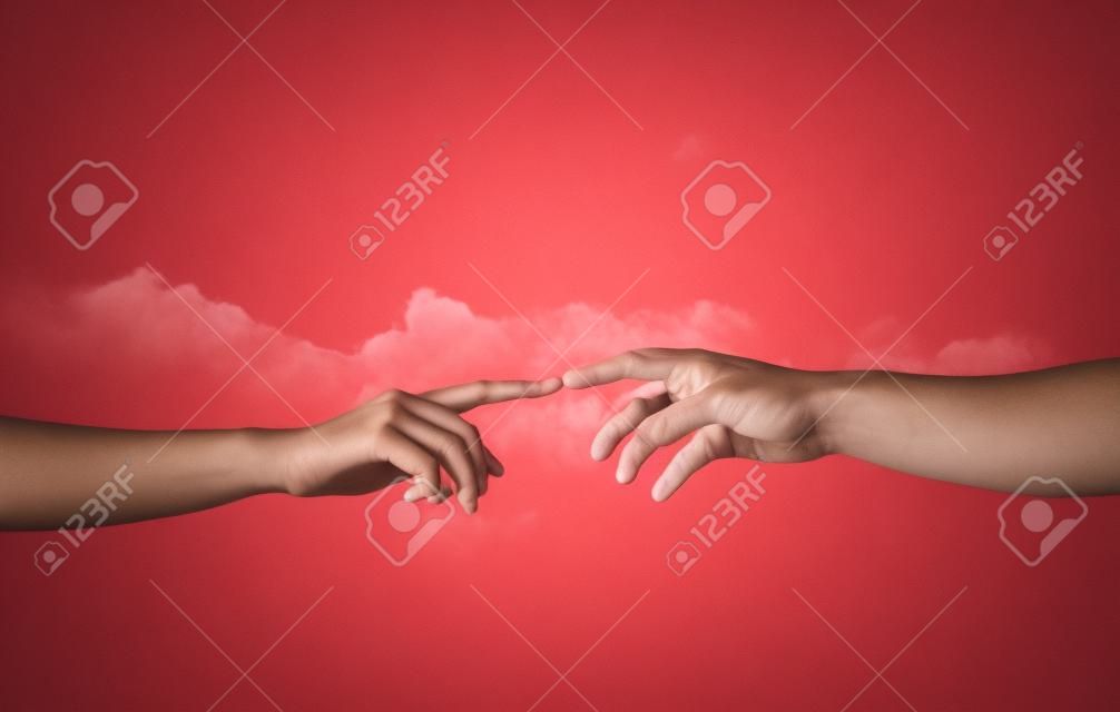 Close up de manos humanas que alcanzan el uno al otro con los dedos