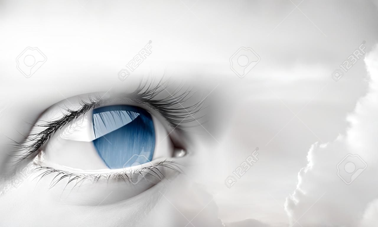 Female blue eye auf bewölkten Himmel Hintergrund
