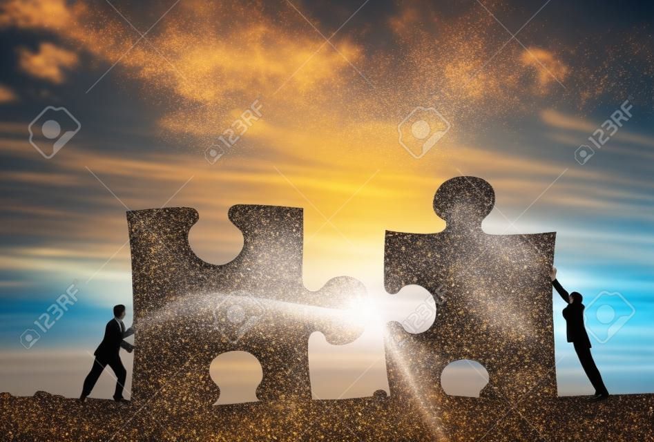 Gente di affari che collega gli elementi di puzzle che rappresentano concetto di collaborazione