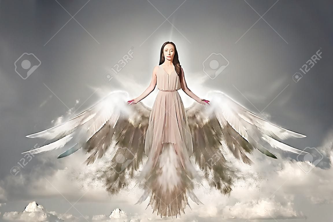 Piękne kobiety w długiej sukni ze skrzydłami w jasnego nieba