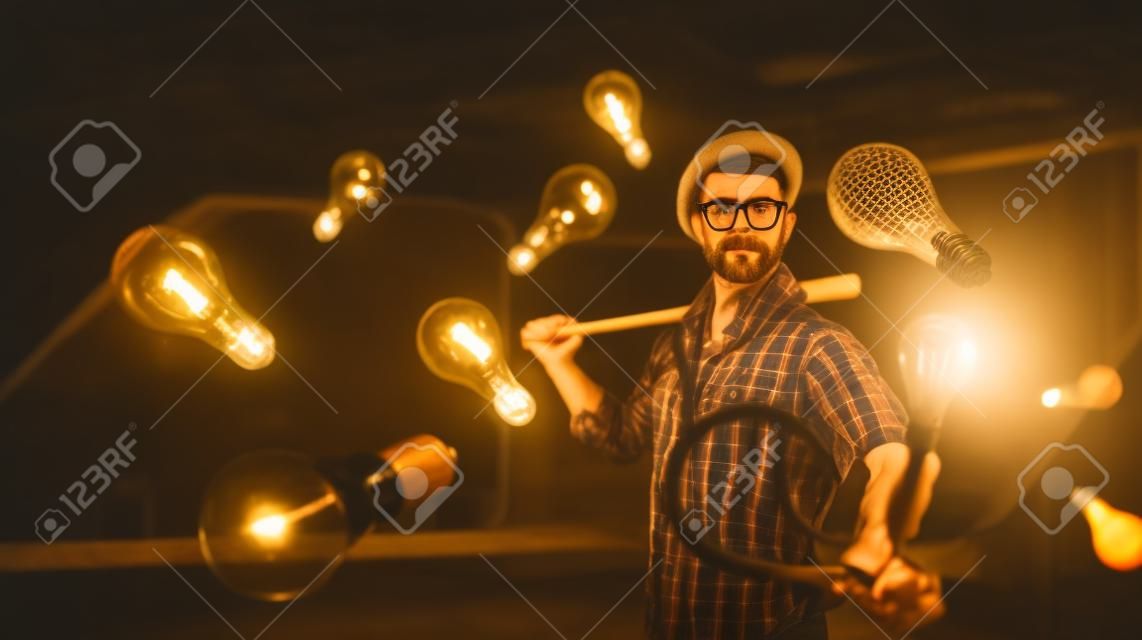 Hipster guy with wooden baseball bat hitting light bulb