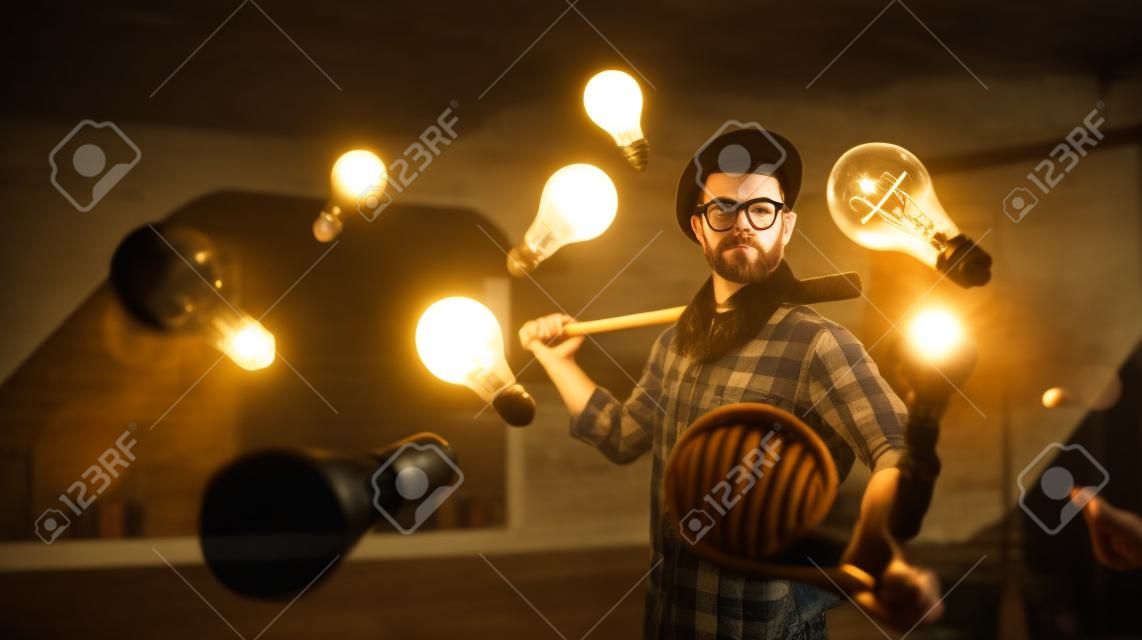 Hipster guy with wooden baseball bat hitting light bulb