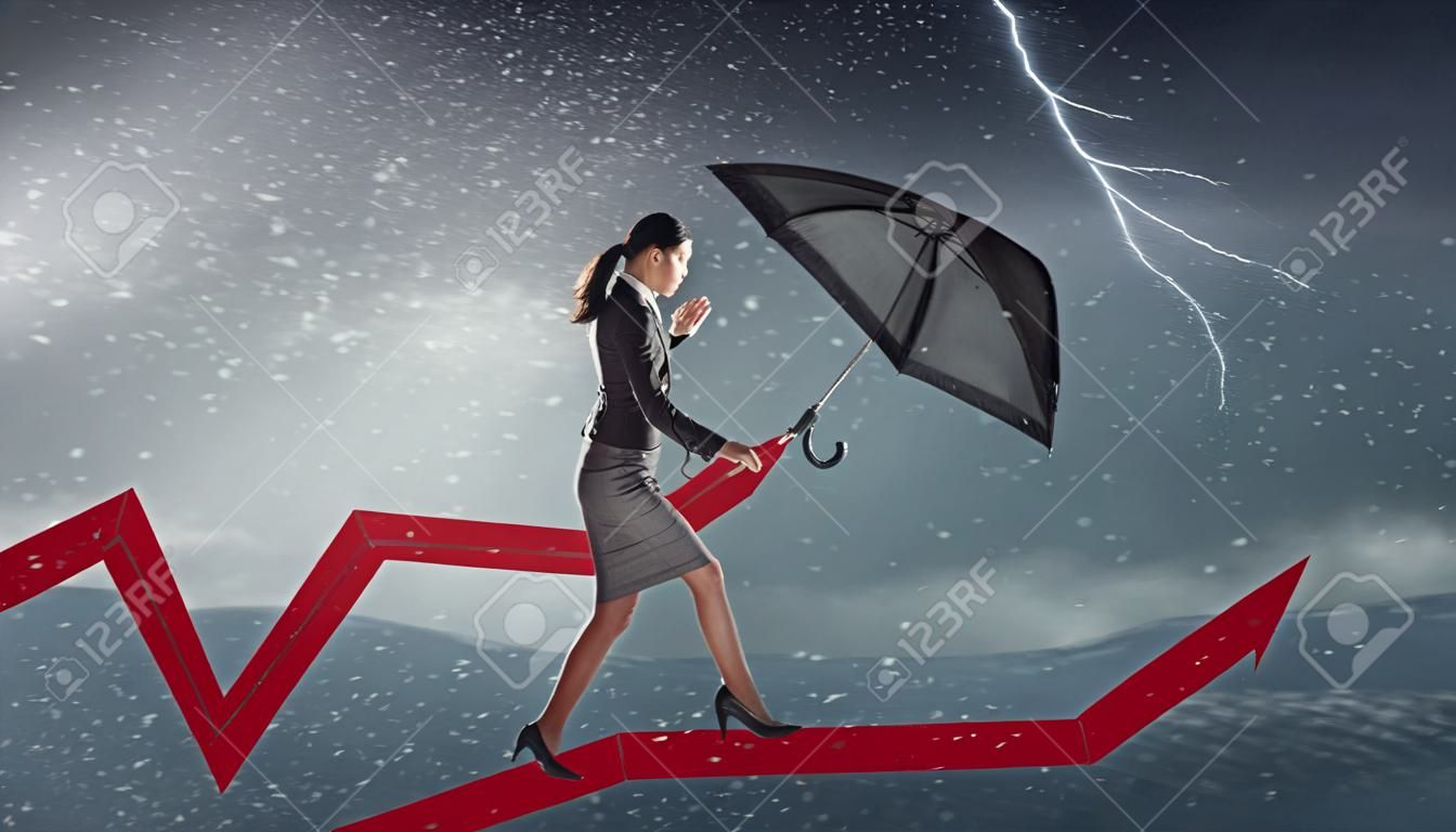 Jóvenes de negocios se determina con paraguas caminando contra el viento fuerte