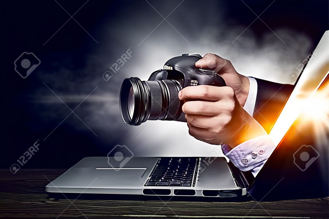 Geschäftsmann vom Laptopbildschirm, der Foto mit Fotokamera macht. Gemischte Medien