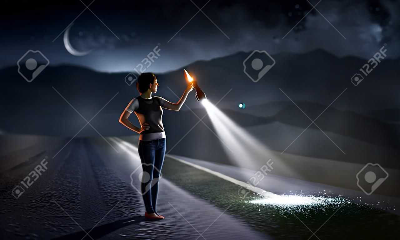 Junge Frau, die eine Taschenlampe hält