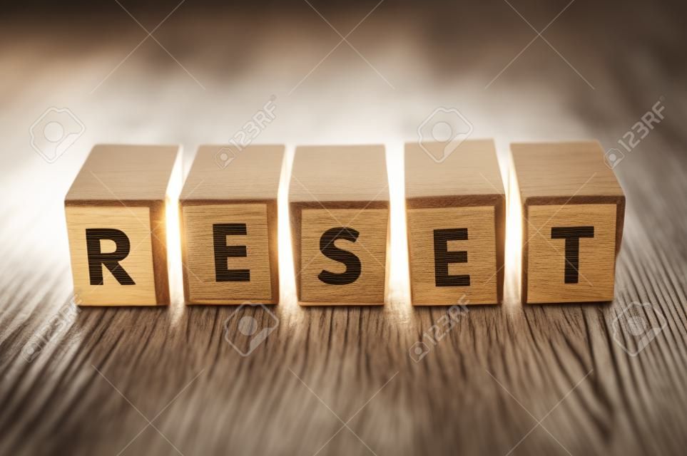 Primo piano della parola sul cubo di legno sul concetto di sfondo della scrivania in legno - Reset