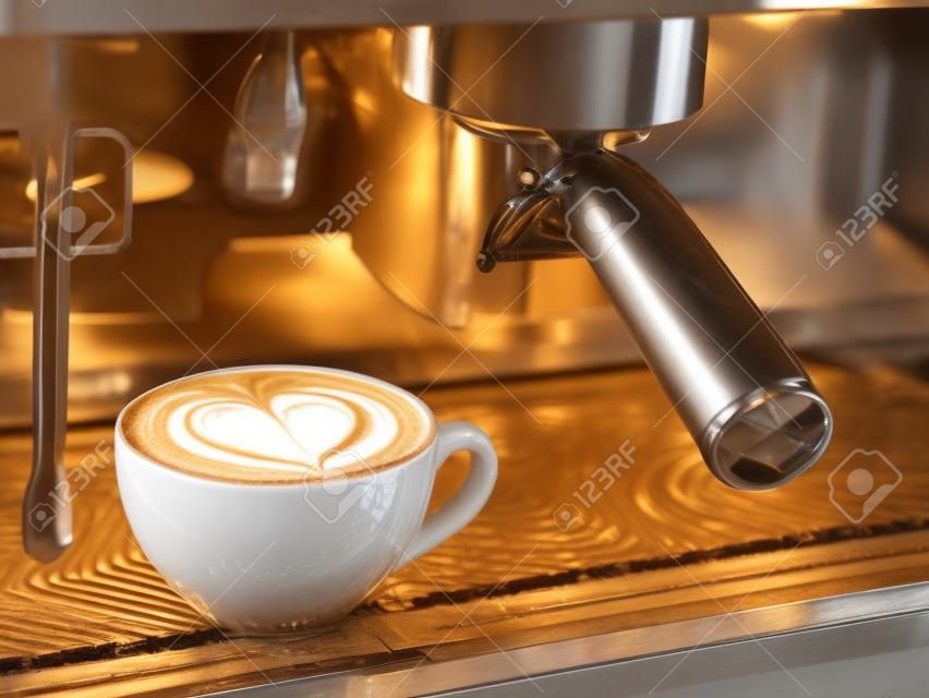 koffie latte kunst patroon hartvorm met machine in koffieshop of cafe.