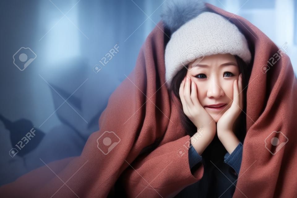 실내에서 따뜻한 겨울옷을 입고 추위를 느끼는 불행한 여성