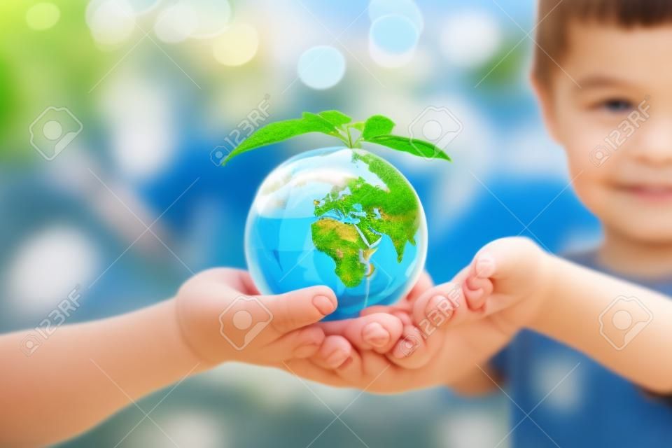 Concetto di ecologia - salvare il pianeta. globo terrestre nelle mani dei bambini
