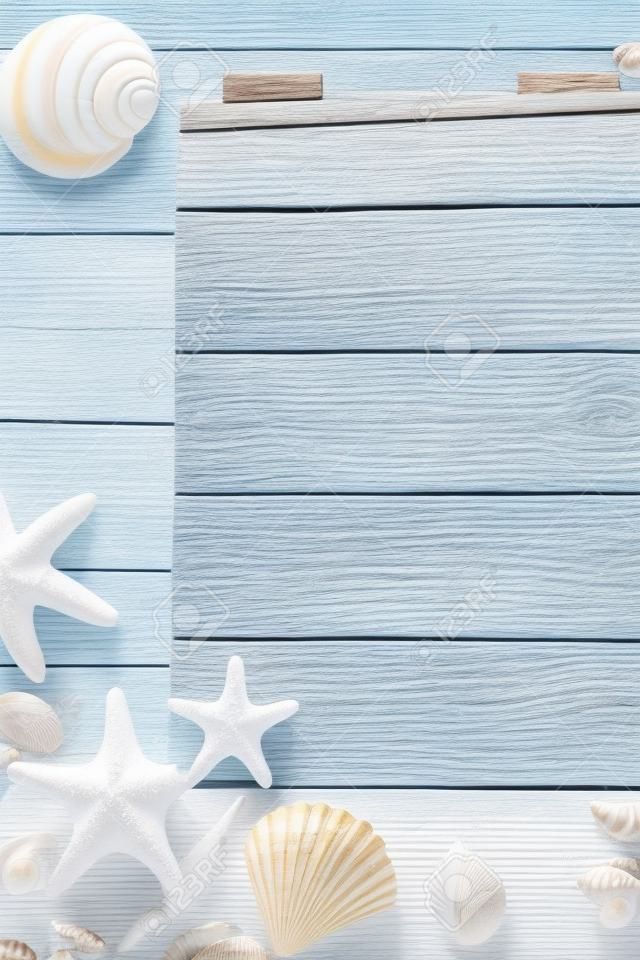 Summer background. Wooden background with white sand and seashells.