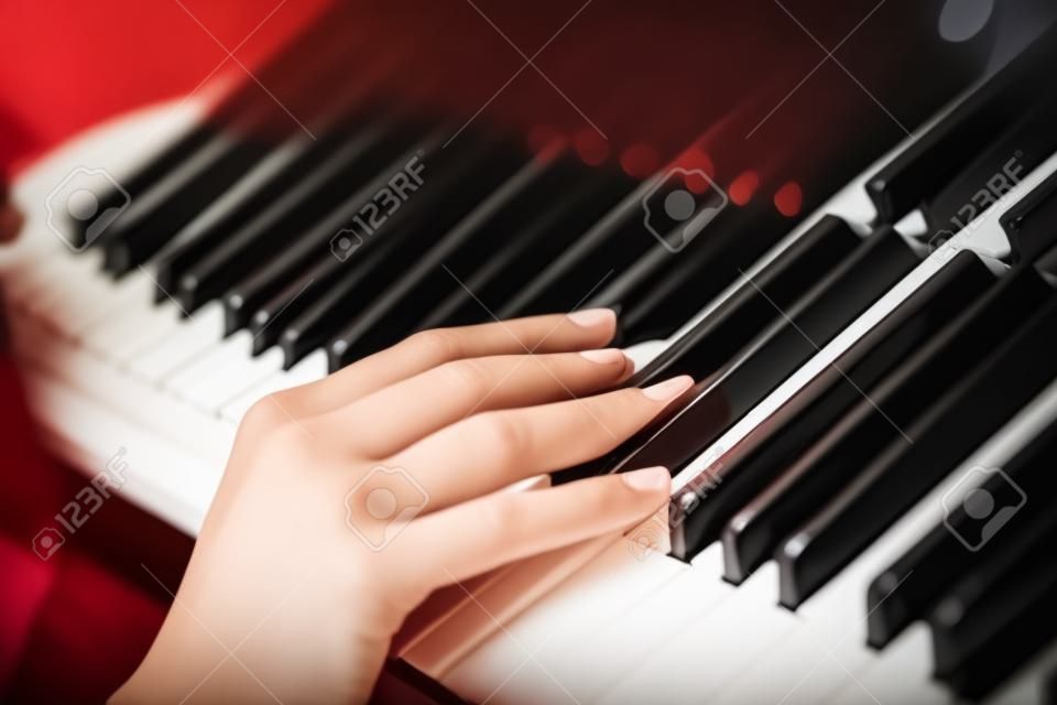 The gentle woman's hand on piano keys