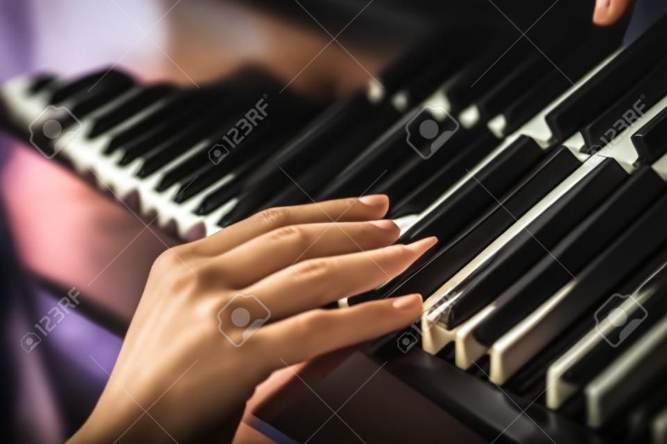 Рука кроткая женщина на клавиши пианино