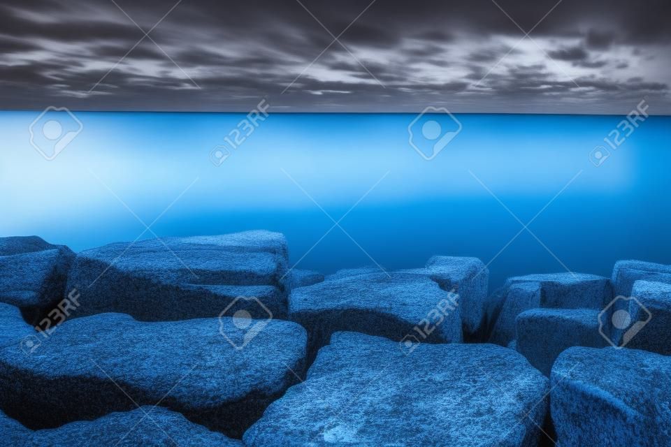 바위와 반짝이는 푸른 호수