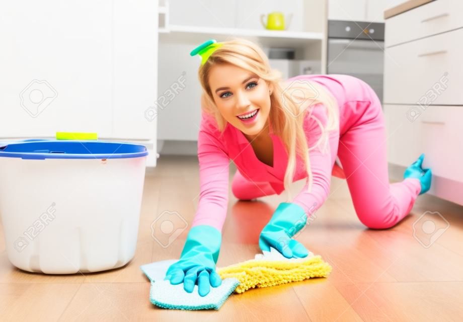 La moglie attraente della casa sta pulendo il pavimento