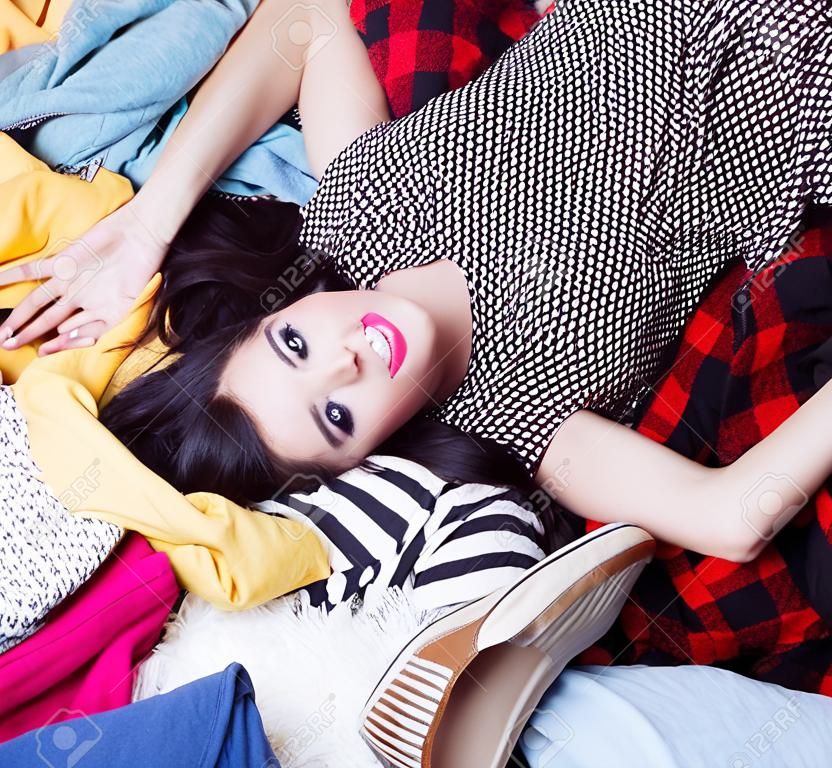 年轻快乐的女人躺在一堆衣服上