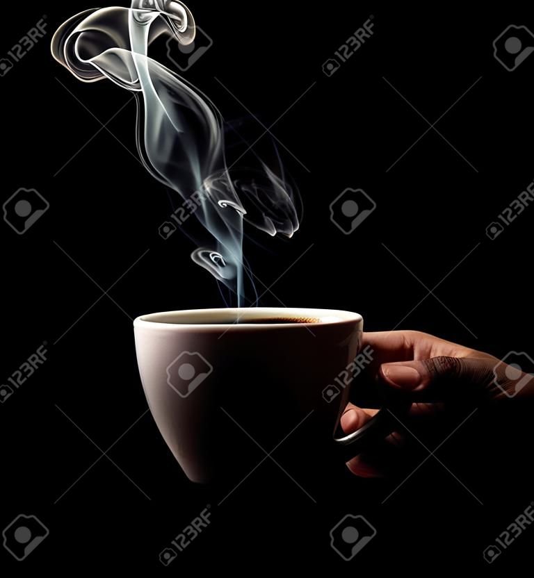 Café perfumado em um fundo preto para sua publicidade. Fumaça de café quente. Uma xícara de café perfumado na mão.