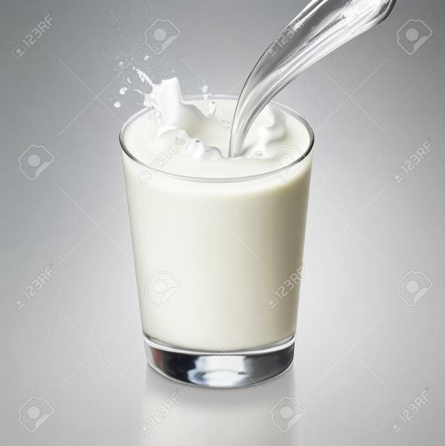 Verse melk gieten in een glazen plons, geïsoleerd op wit