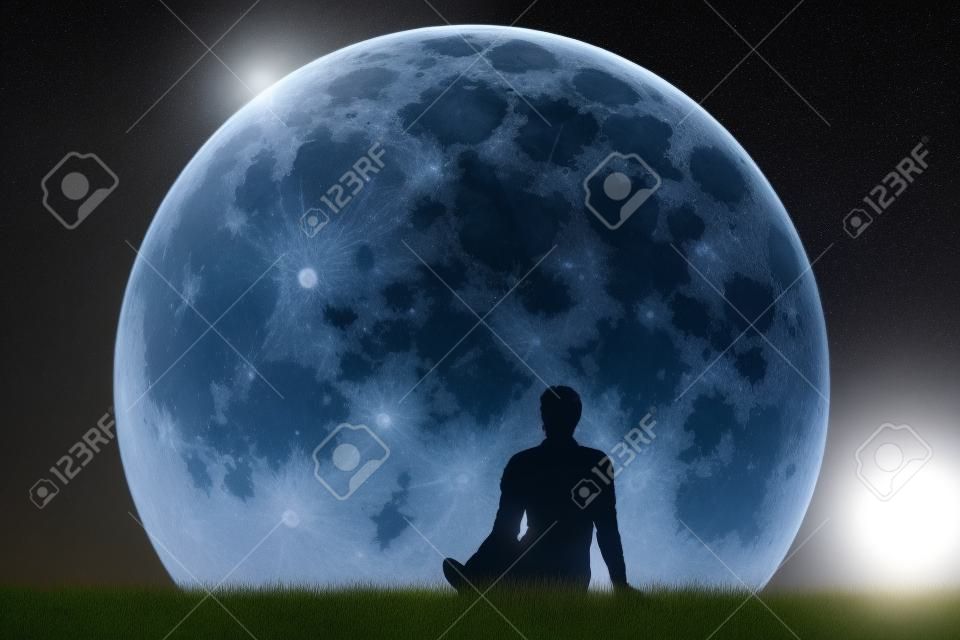 Mężczyzna siedzi sam na trawie i patrząc na księżyc. Wyobraź sobie przyszłość. Grafika trójwymiarowa. Elementy tego obrazu dostarczone przez NASA