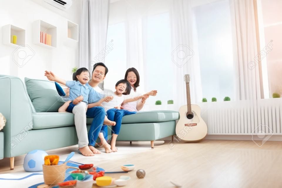 Gelukkige Aziatische familie in woonkamer thuis, samenzijn ontspanning concept