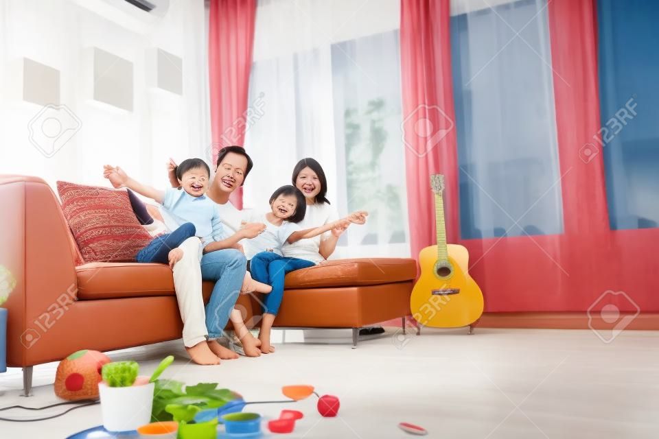 Счастливая азиатская семья в гостиной дома, концепция релаксации единения
