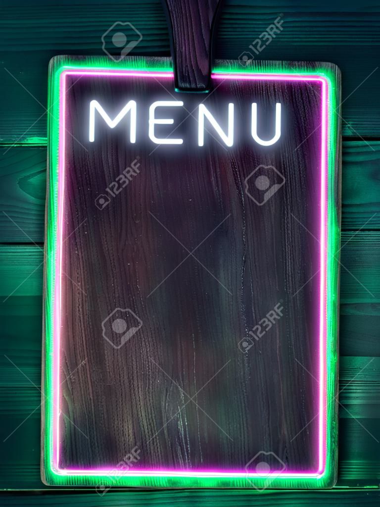 vintage wooden brown cutting board with neon green and pink lights, menu signboard, template for restaurant, pub, copy space