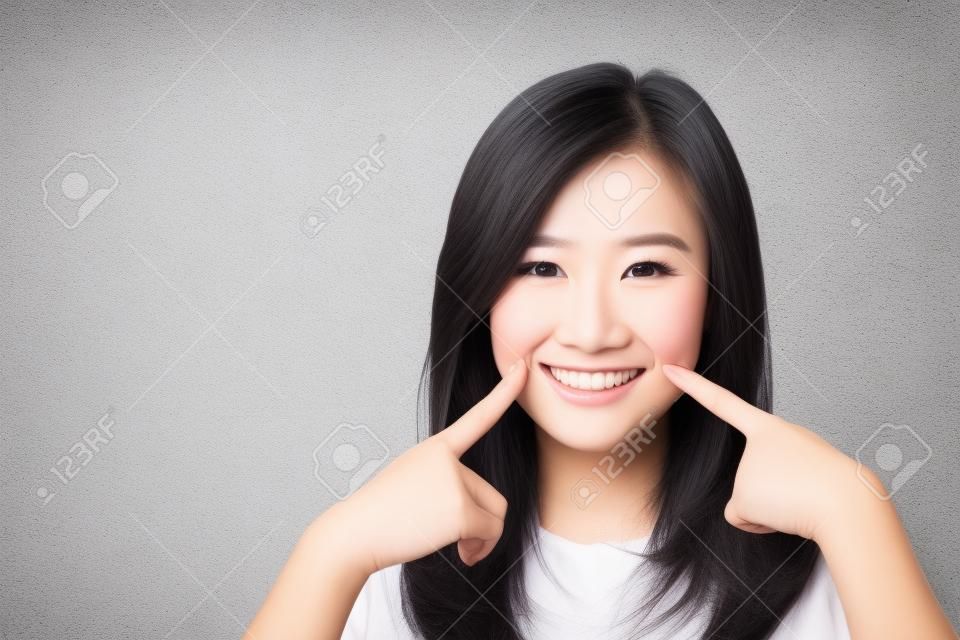 Retrato da bela jovem mulher asiática felicidade de pé dedo toque bochecha no fundo de tijolo de parede de grunge textura de cimento cinza, mulher de negócios é um sorriso no conceito de concreto, pessoas de negócios.
