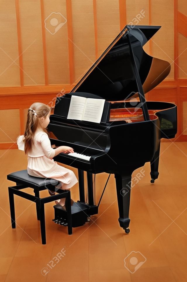 little girl playing the grand piano
