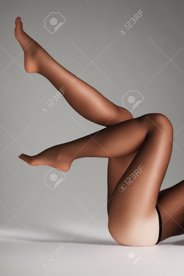 Femme jambes en l'air, fond blanc