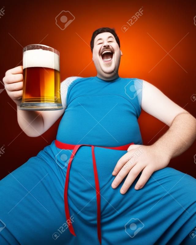 Retrato de hombre gordo divertido con un vaso de cerveza