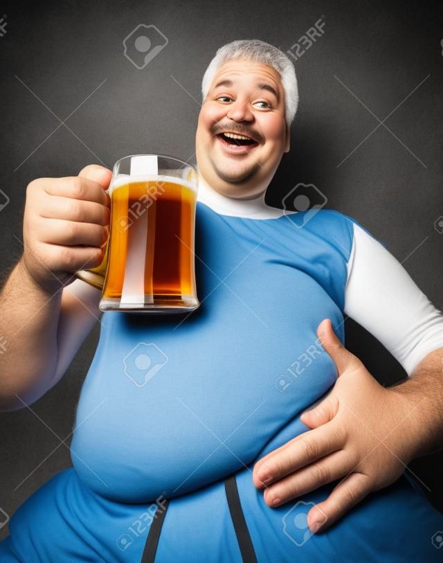 Ritratto di divertente uomo grasso con un bicchiere di birra