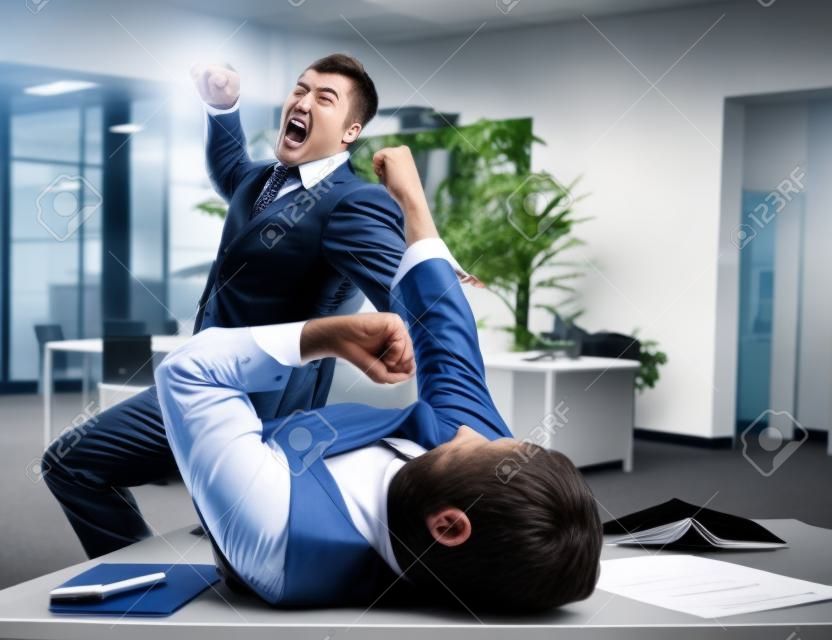 Dos hombres de negocios furiosos que luchan en la oficina
