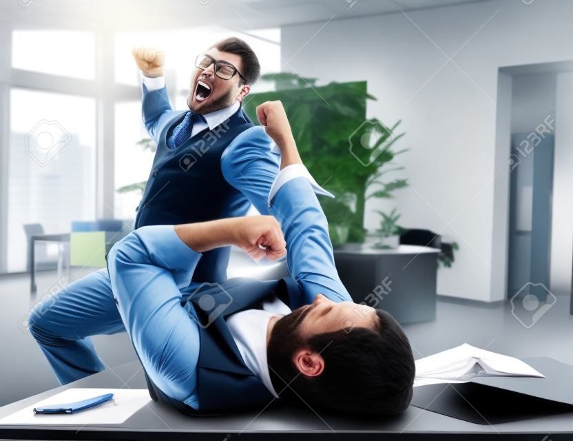 Due uomini d'affari furiosi combattimenti in ufficio