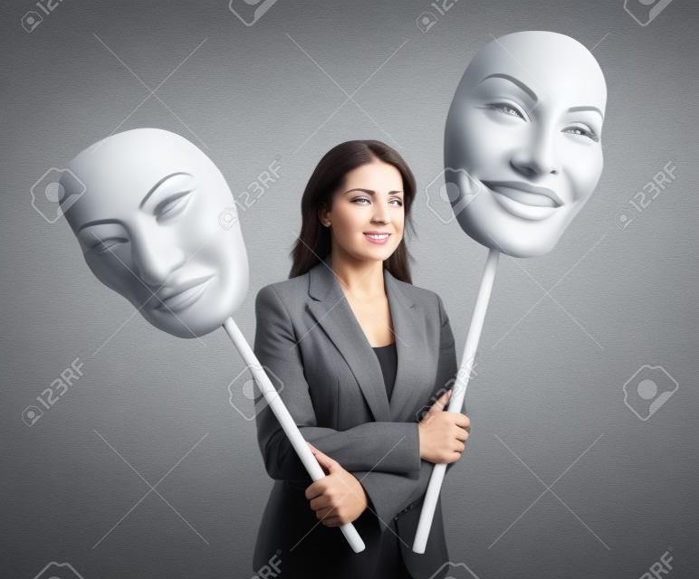 Businesswoman choosing face over grey background