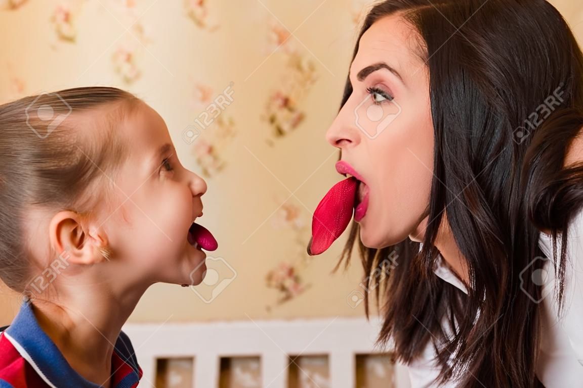 Jonge moeder en het meisje laten elkaar tongen zien.