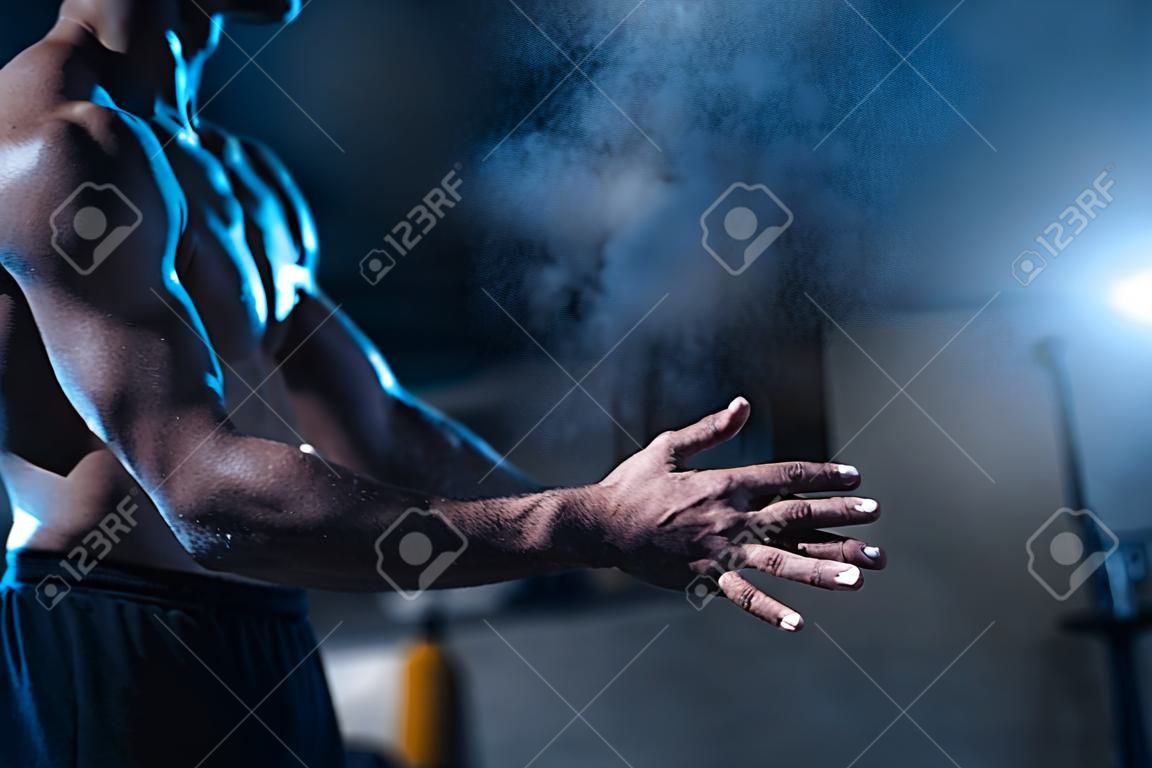 남성 운동 선수는 활석 가루로 손을 문지른다.