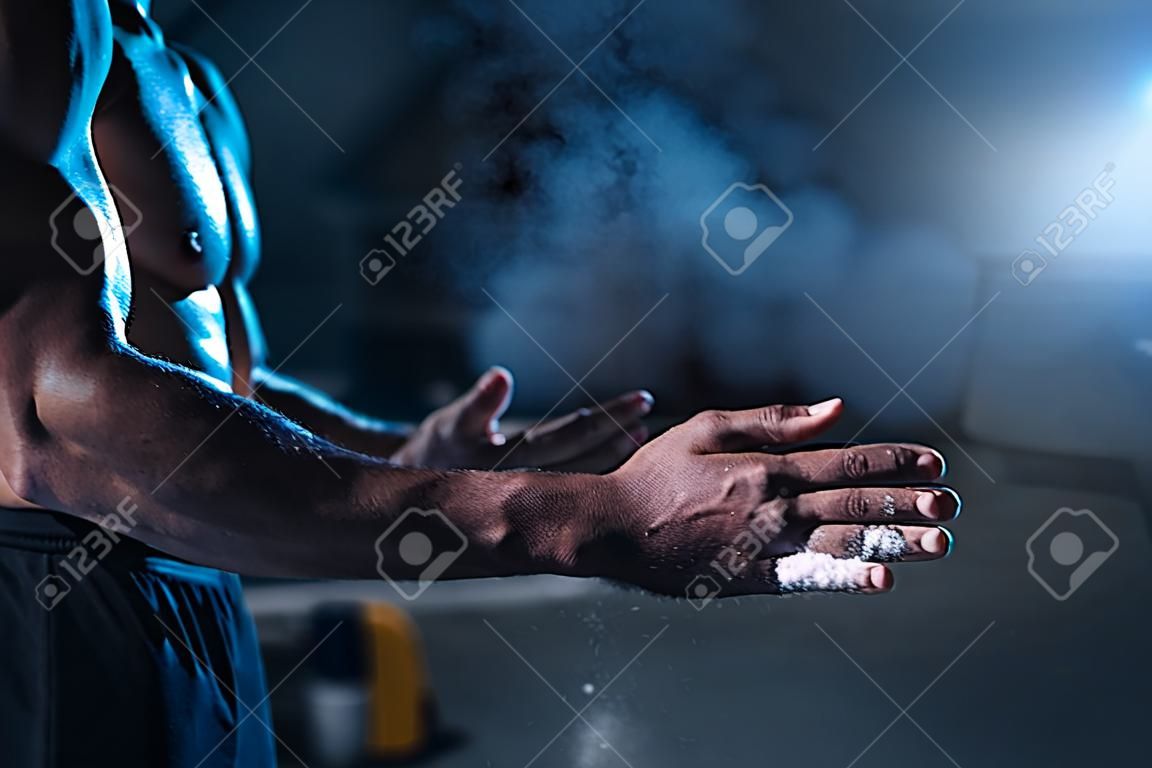 Male athlete rubs hands with talcum powder