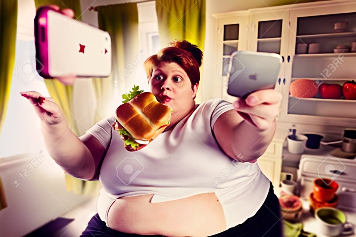 Grosse femme mange un sandwich et fait selfie, obésité