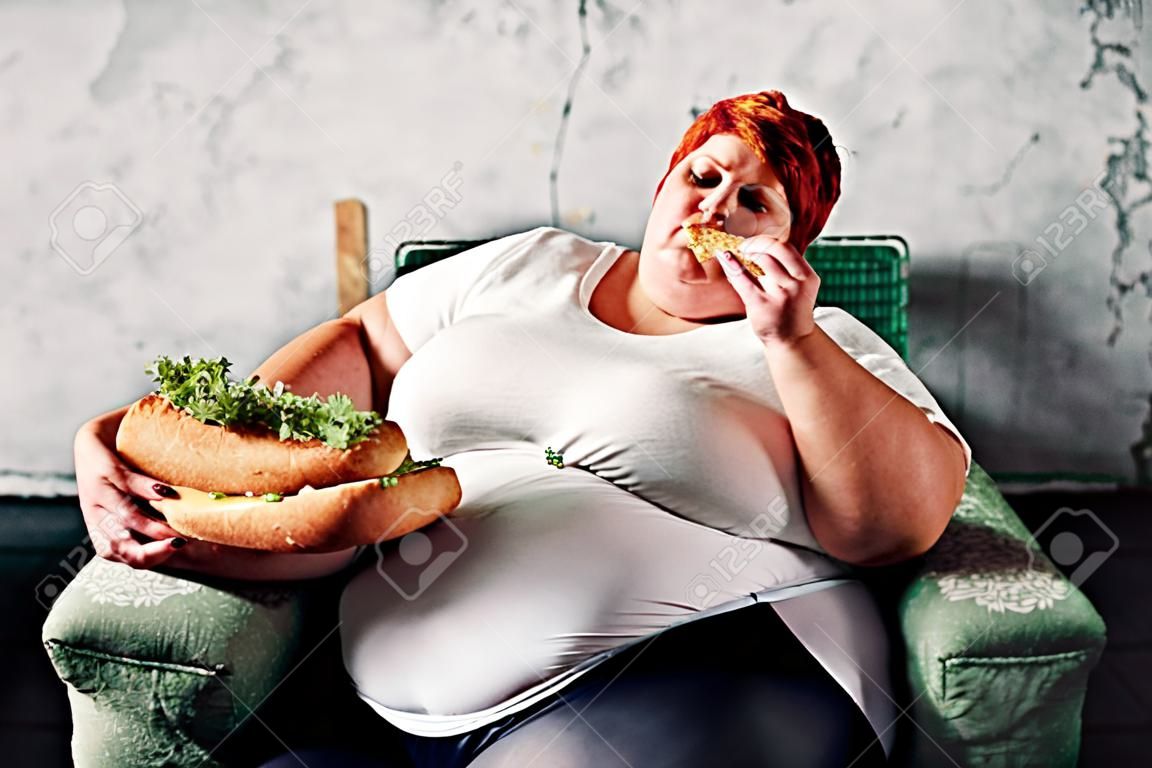 Mujer gorda come sandwich, sobrepeso, grasa.