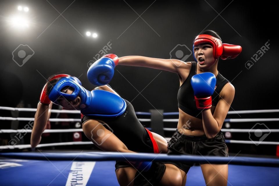 Female kickboxers in action, fighting on the ring