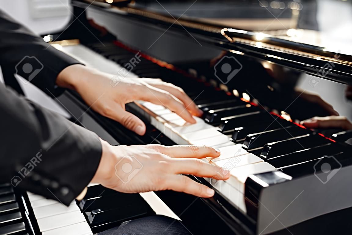 Mãos de pianista masculino no teclado de piano de cauda