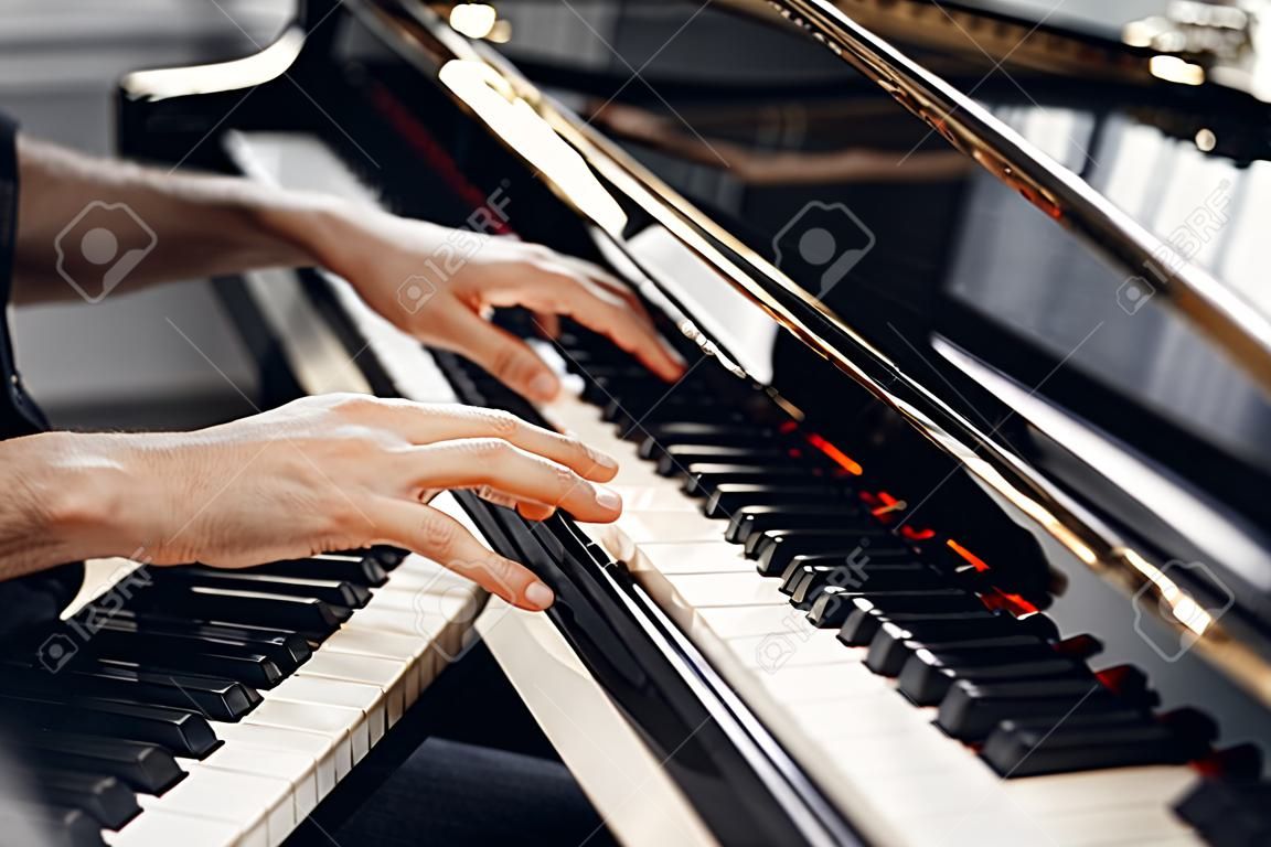 Mãos de pianista masculino no teclado de piano de cauda
