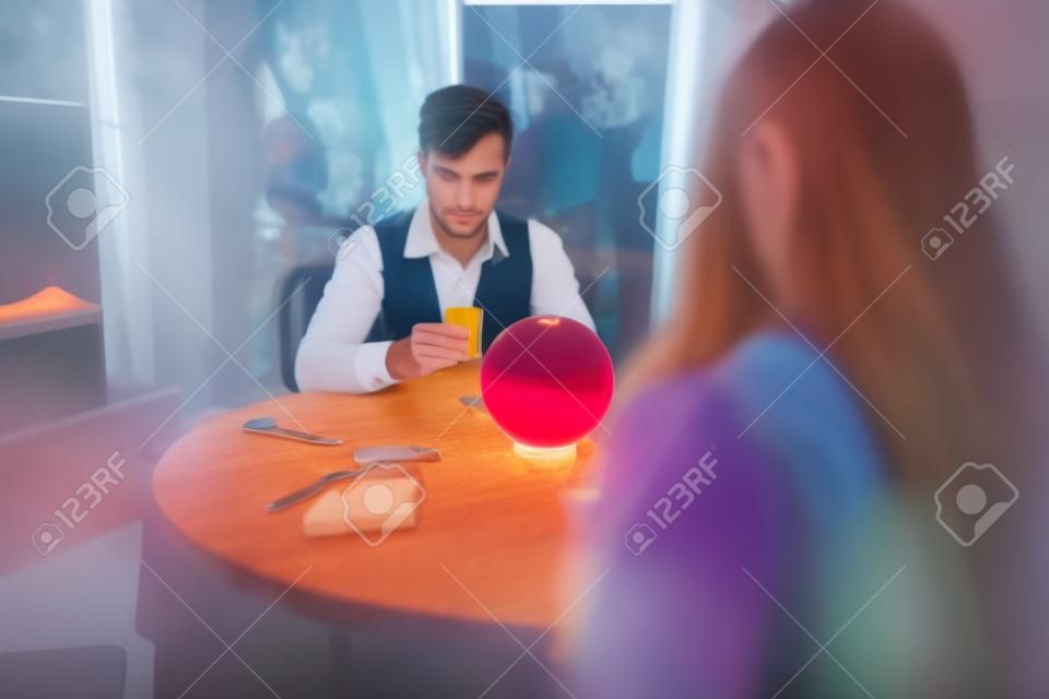 Jóvenes en la mesa con bola de cristal
