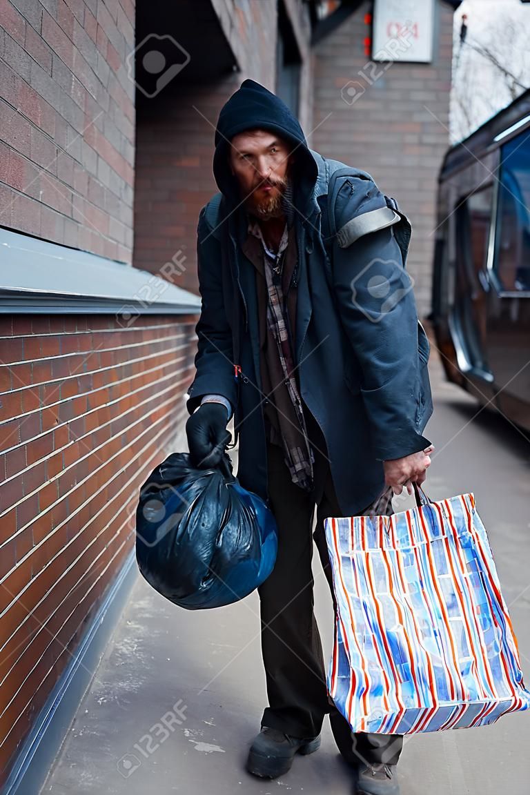 Homeless man with bag on city street