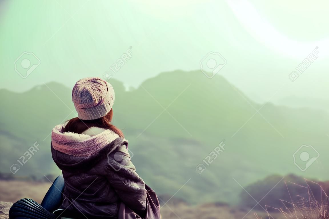 여성 등산객은 산 정상에서 전망을 즐깁니다.