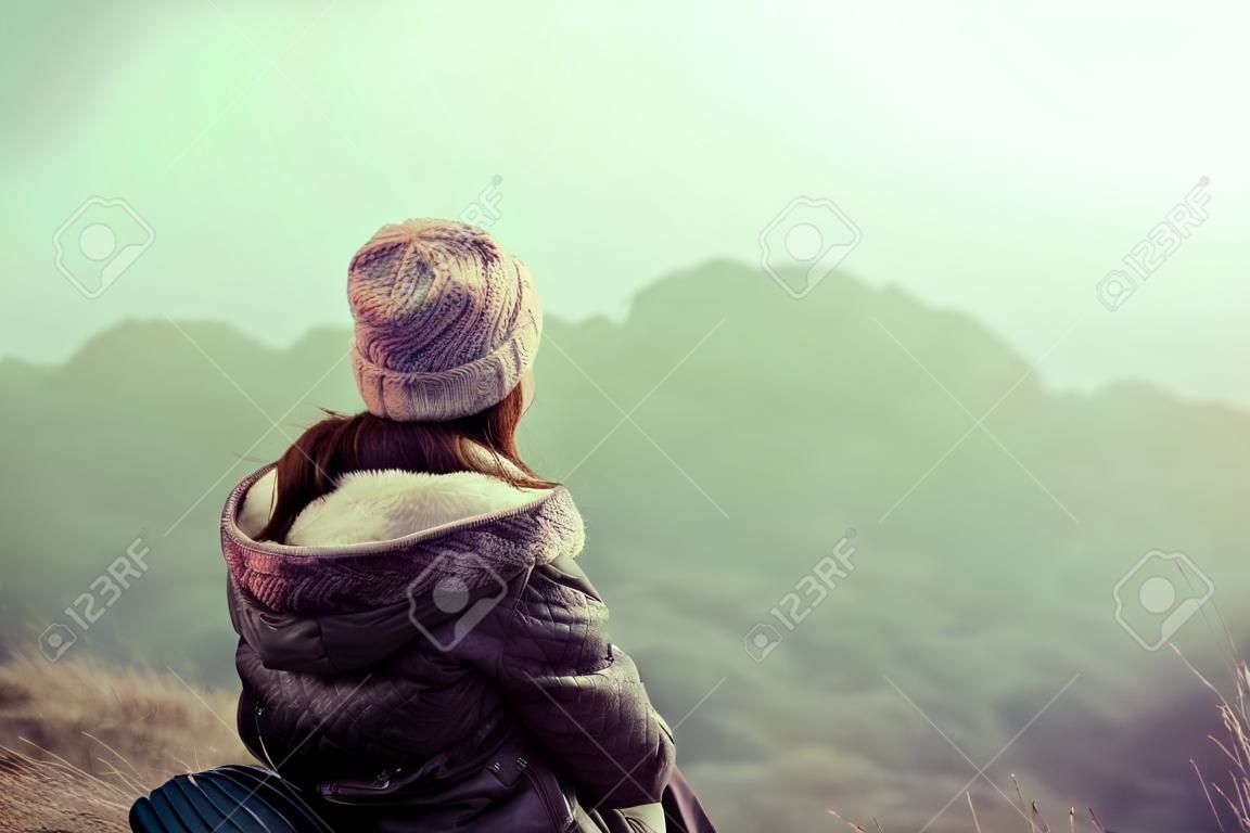 여성 등산객은 산 정상에서 전망을 즐깁니다.