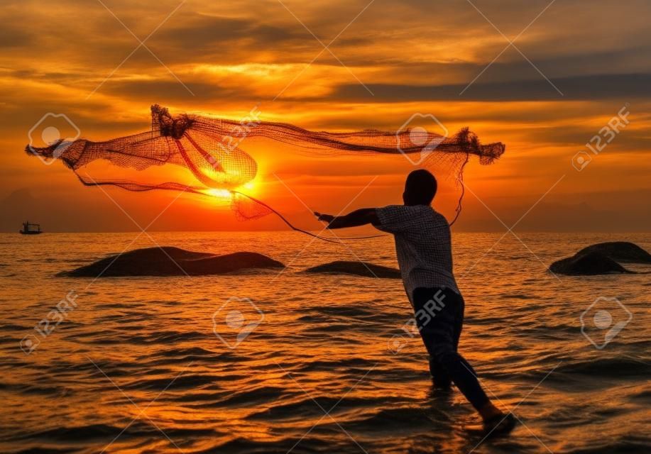 jeter le filet de pêche pendant le coucher du soleil, thaï