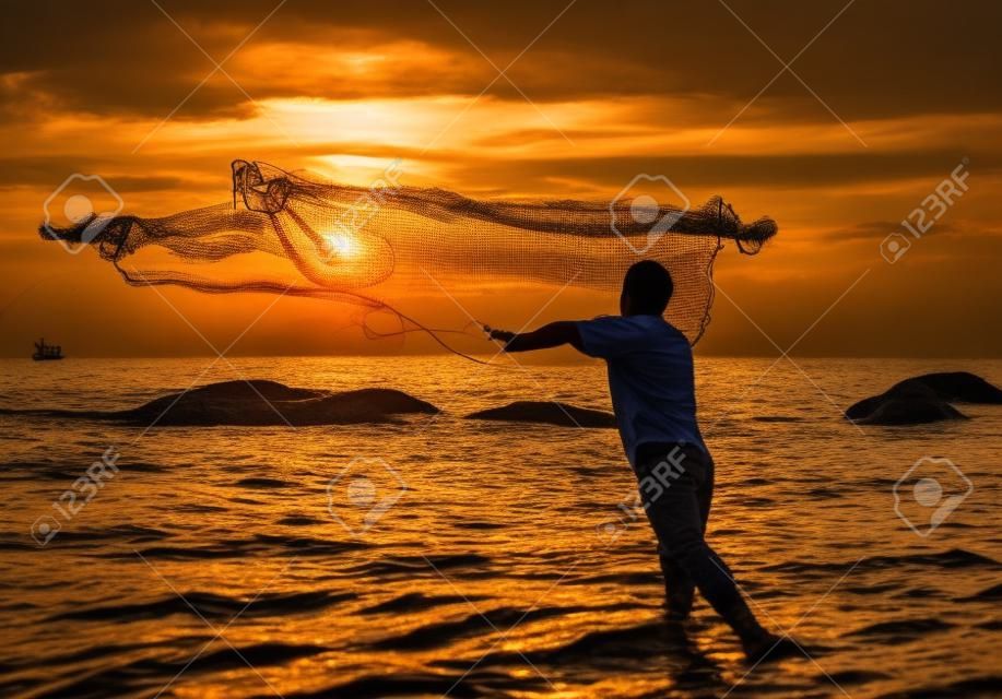jeter le filet de pêche pendant le coucher du soleil, thaï