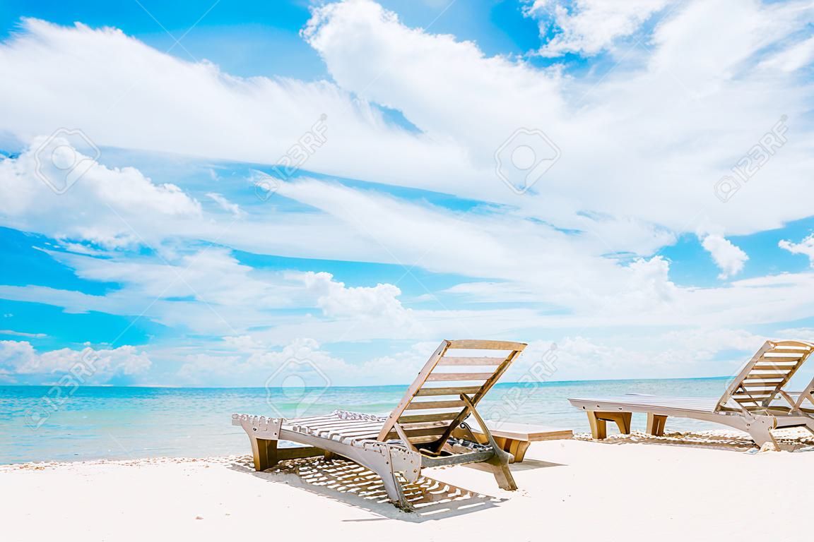 Cadeira de praia na praia de areia branca, o céu claro é perfeito para banhos de sol. ou relaxar nos fins de semana de verão.